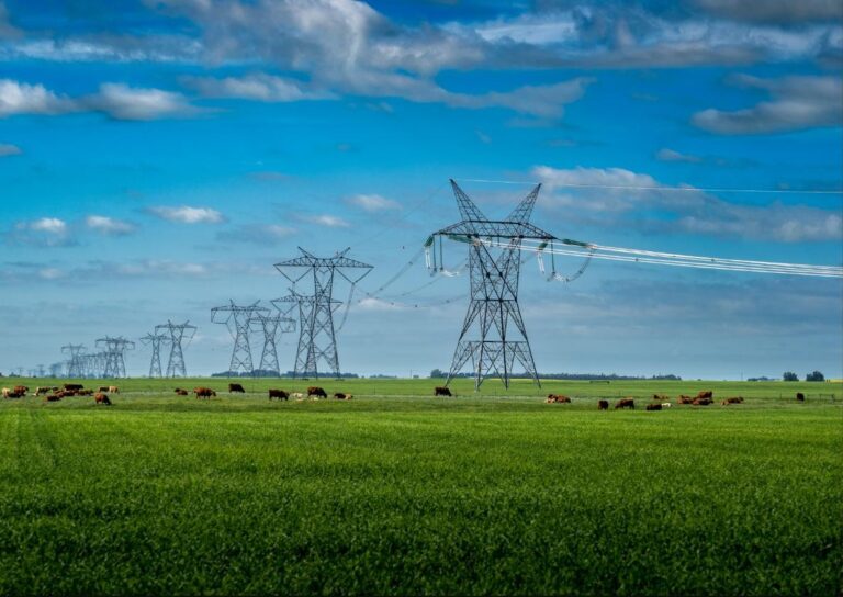 Utilities sector — high-voltage electricity transmission towers and power lines across rural farmland